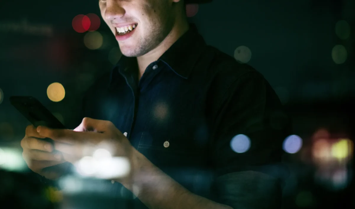Scastlivyi Molodoi Vzroslyi Muzcina Ispol Zua Smartfon V Nocnom Gorodskom Peizaze