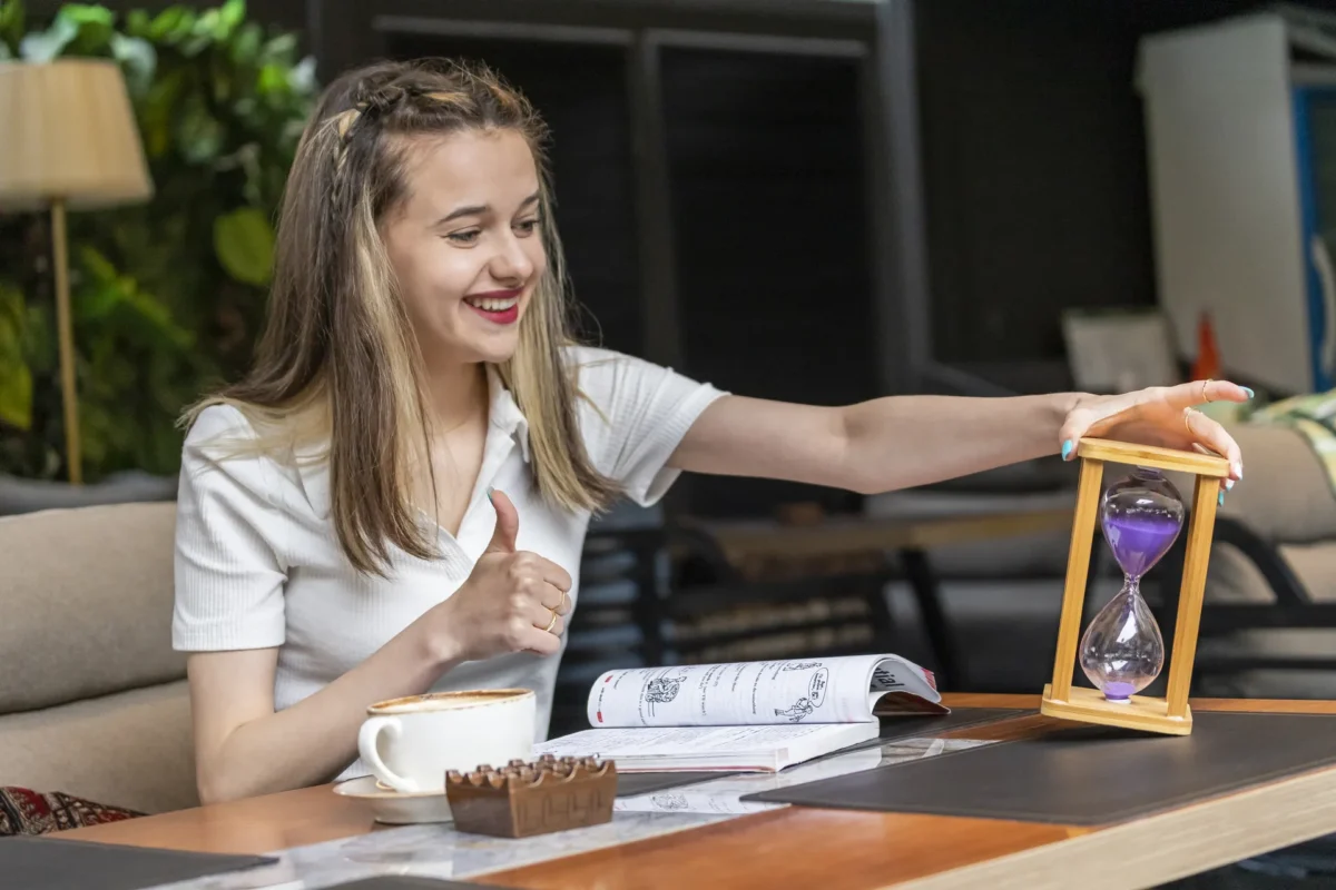 Smiling Lady Holding Hourglass Gesture Thumb Up
